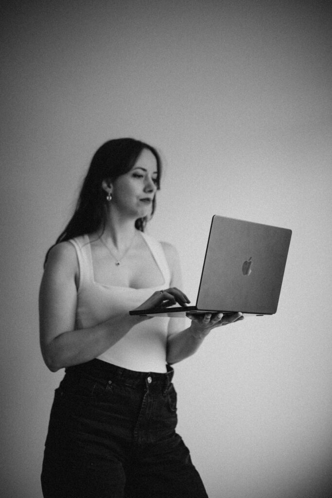 Wedding Business holding laptop using Studio Ninja Discount Code